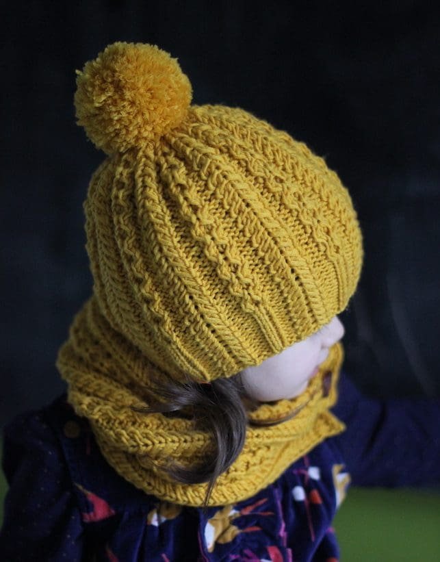 Child wears Ropes n Pearls Set. Mustard yellow knit hat with pompom and matching cowl. Winter knitwear.