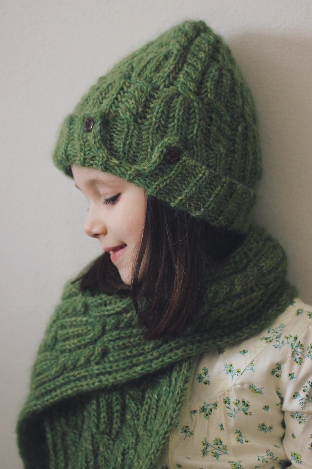 Girl in green knitted hat and scarf. Winter fashion, cozy knitwear.