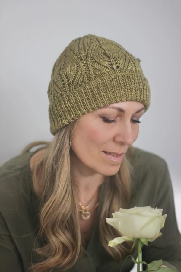 Woman in green knit beanie. Close-up of a blonde woman wearing a knitted hat. Winter fashion.