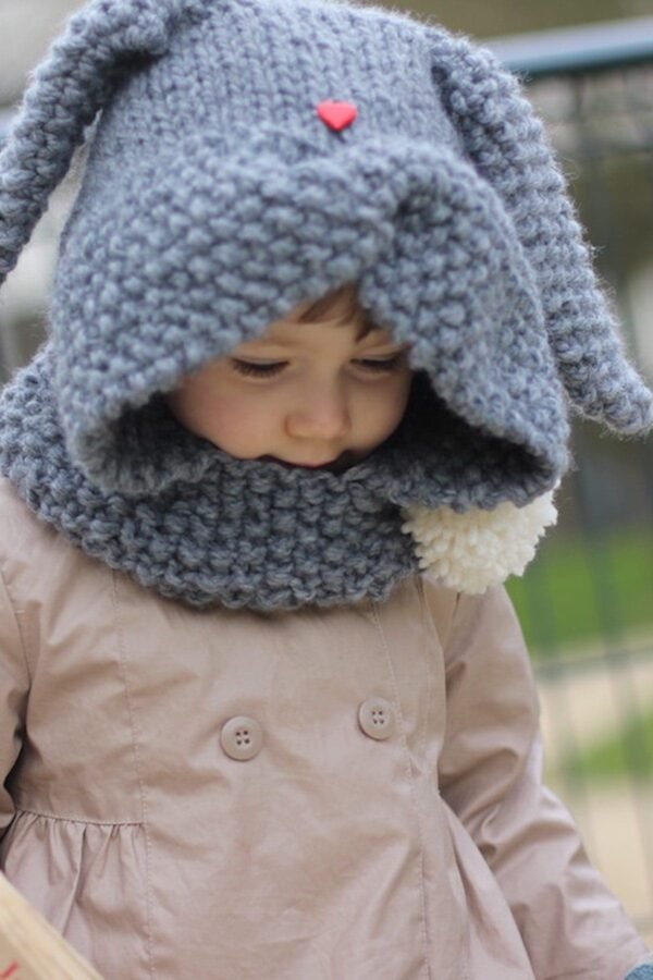Child wearing a cozy, gray knit hat with pom-pom. Winter fashion for kids.