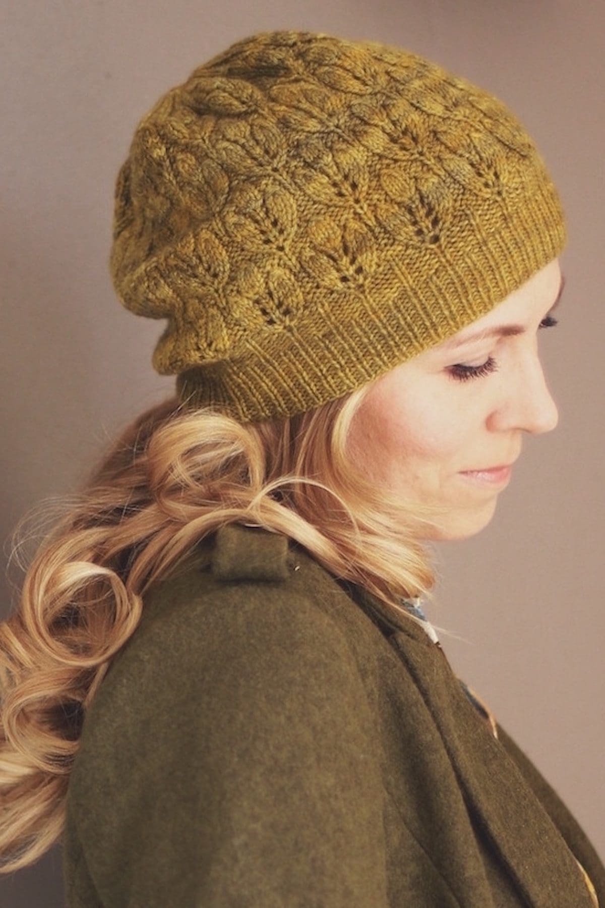 Woman in knitted hat. Close-up of blonde hair and olive green knit beanie. Fall fashion.