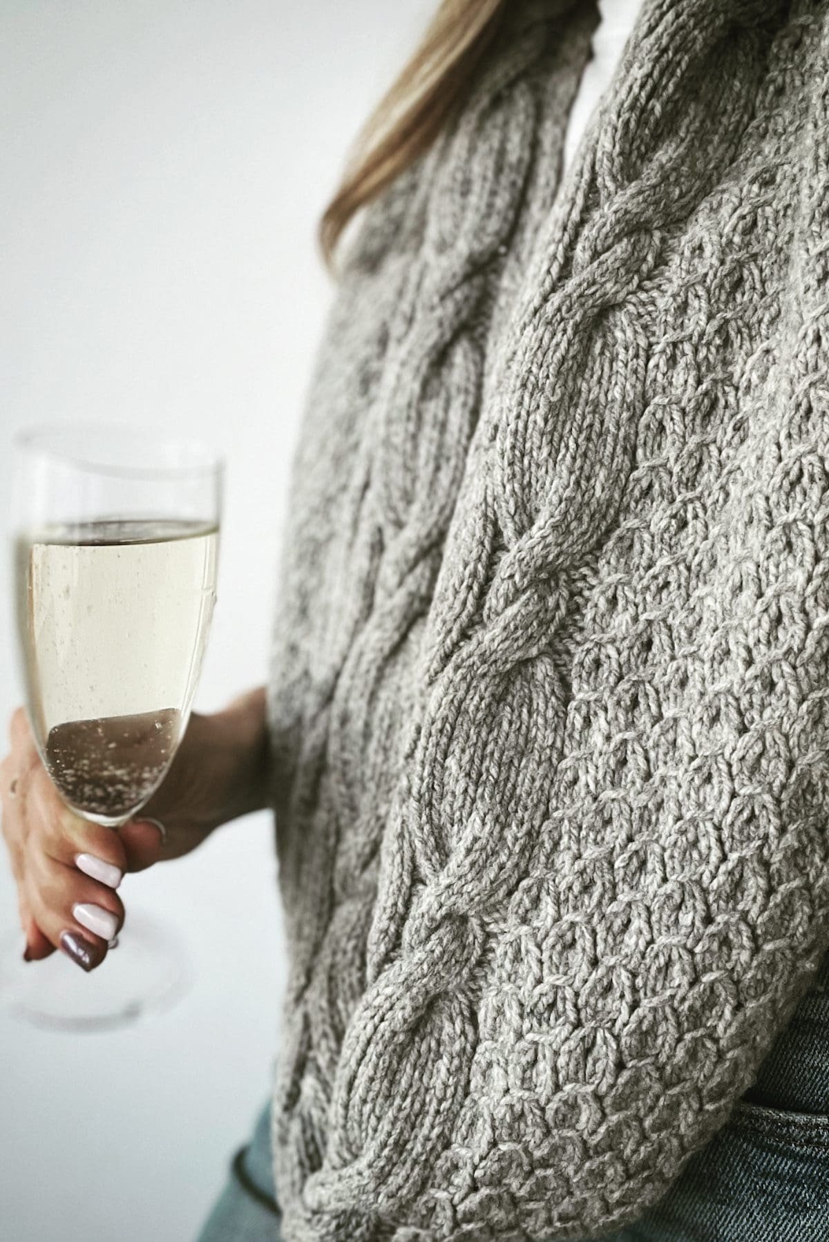 Grey knit cowl sweater with bubbles in a glass. Cozy fashion.