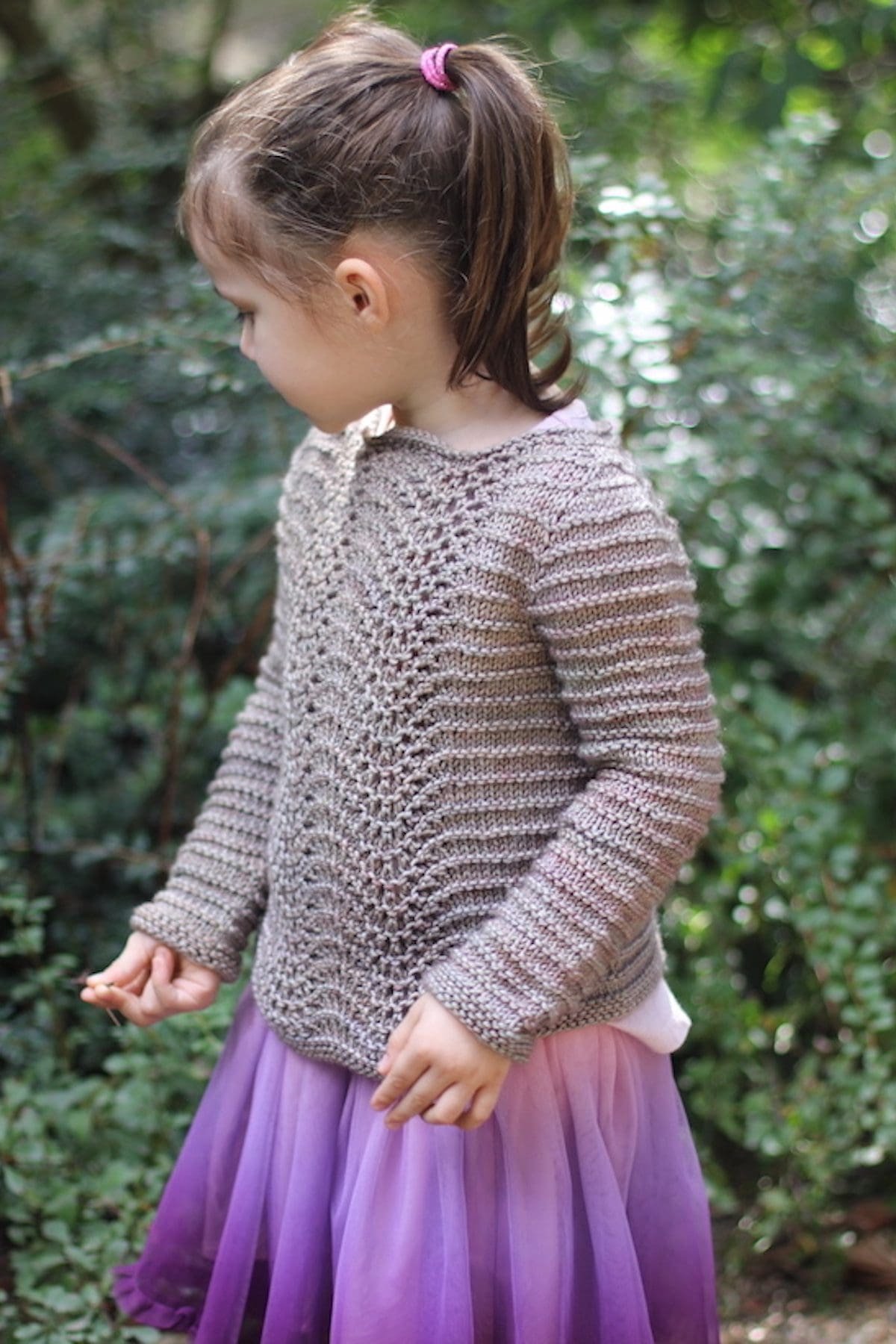 Child wearing a handmade knitted sweater. Cozy knitwear fashion.