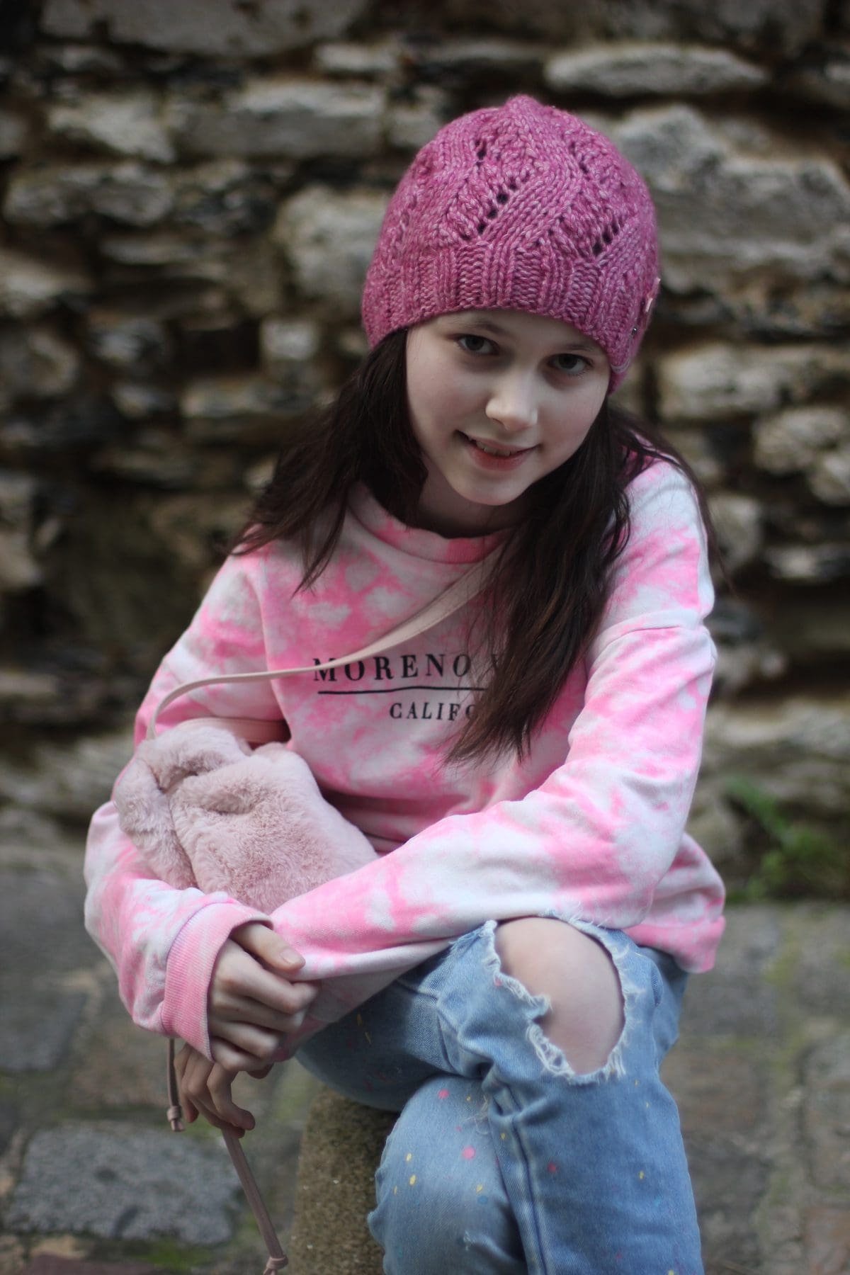 Girl in pink tie-dye sweatshirt. Moreno California text. Fashionable, cute.