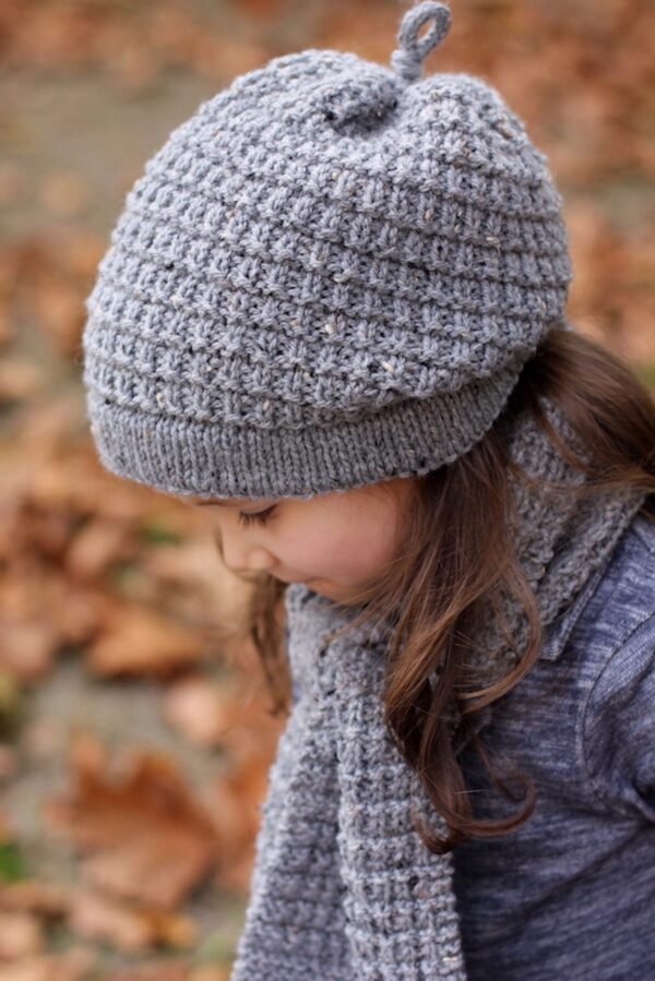 Girl wearing gray knit hat and scarf. Winter fashion.