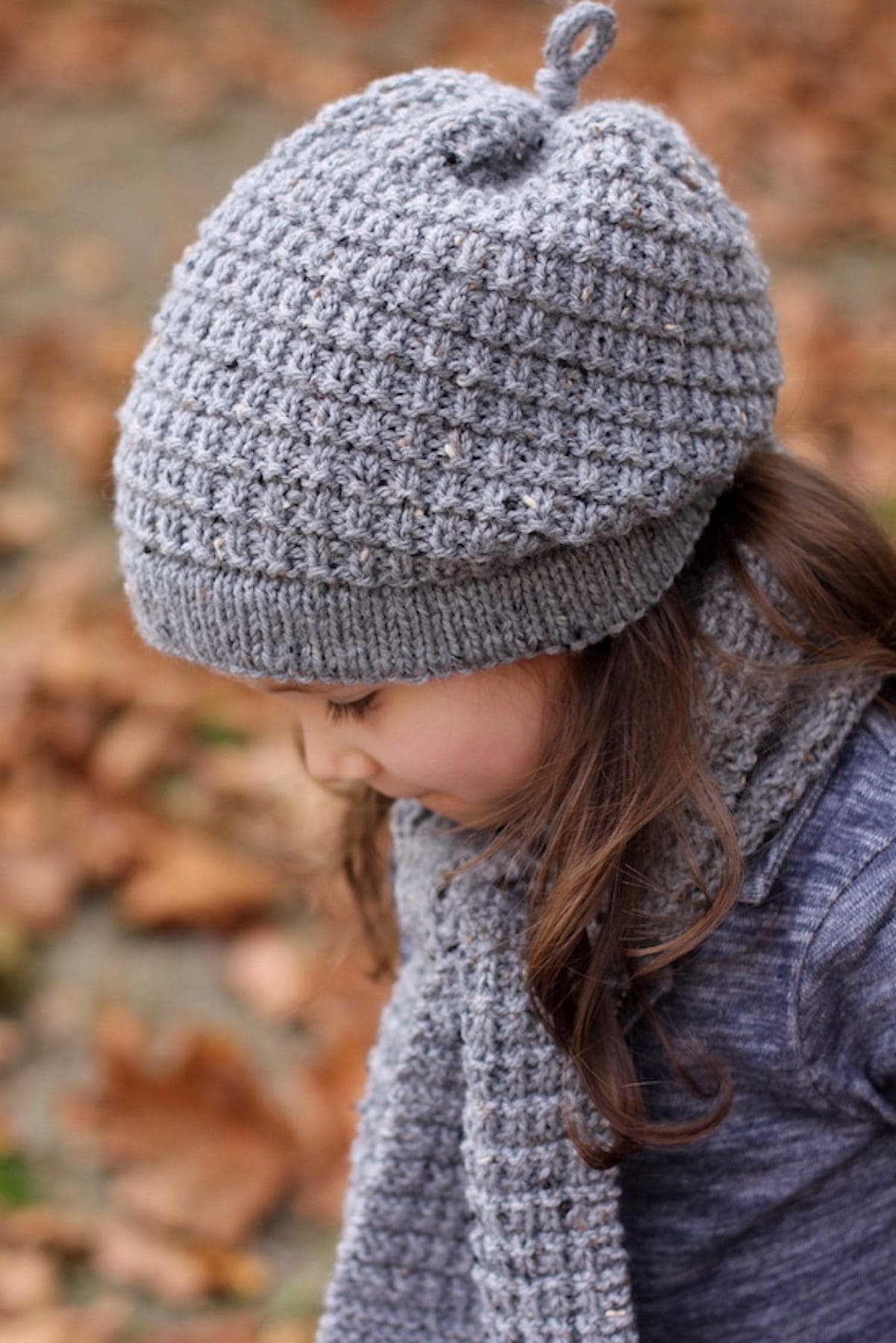 Girl wearing gray knit hat and scarf. Winter fashion.