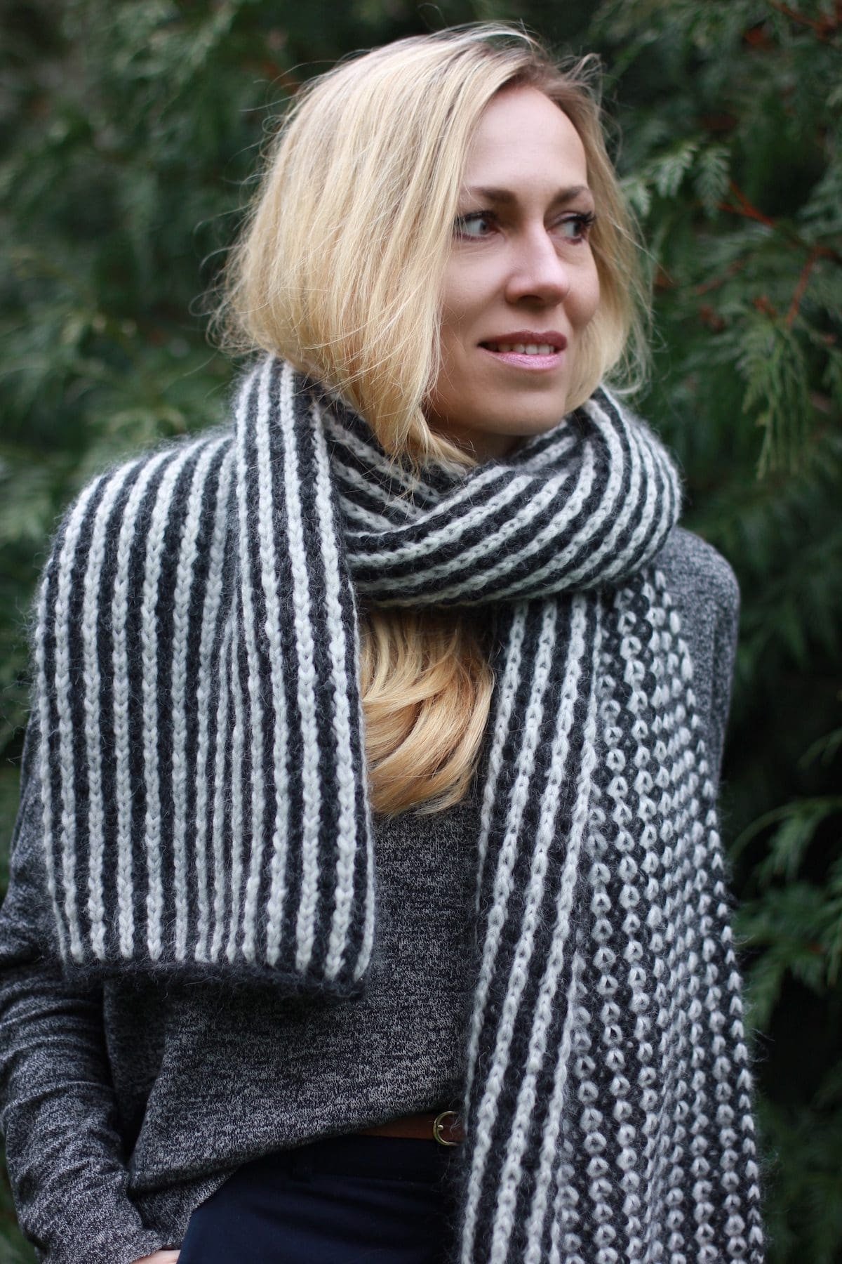 Woman wearing a striped knit scarf. Warm winter fashion accessory.