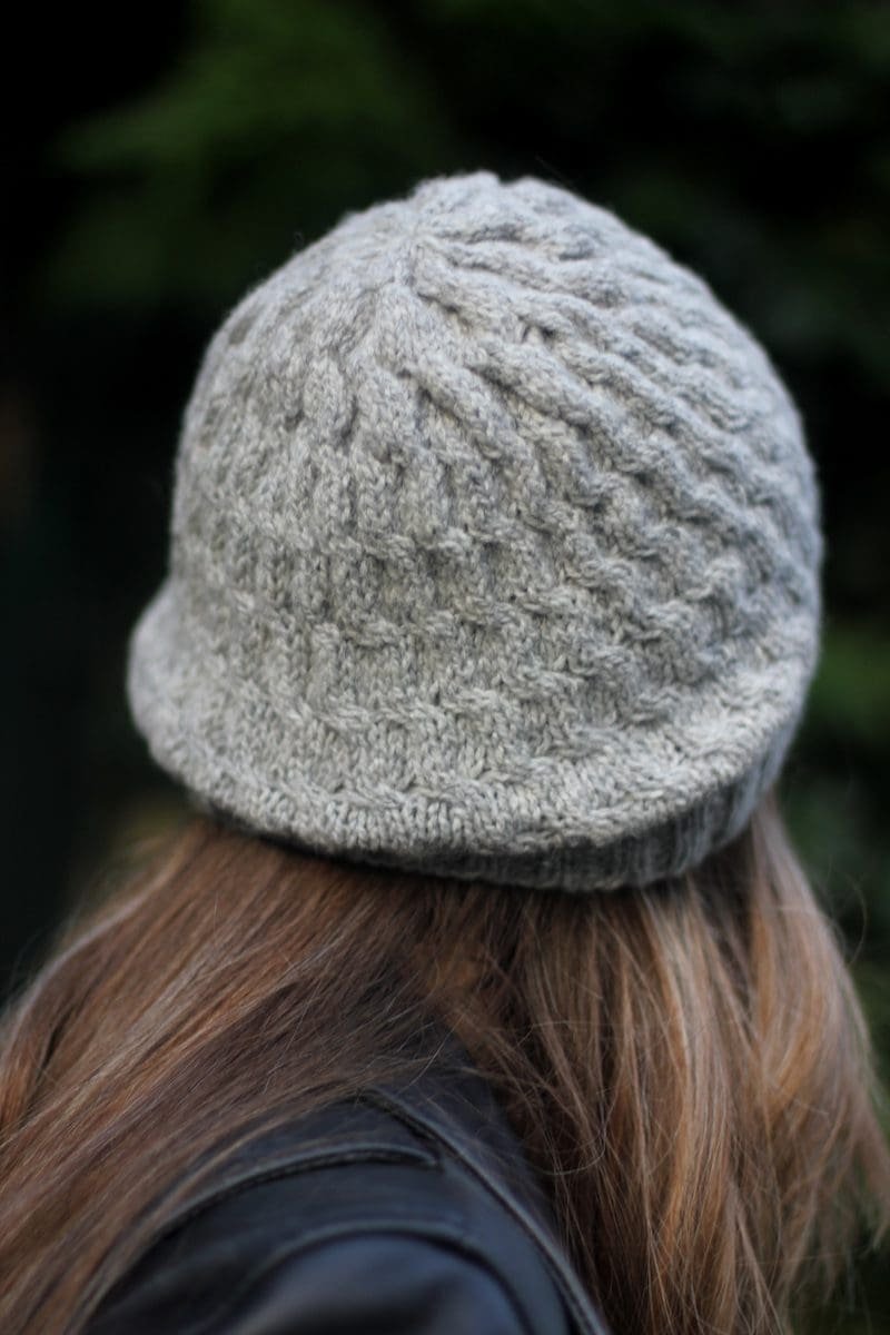 Back view of a woman wearing a gray, knitted Soft Swell Beanie.