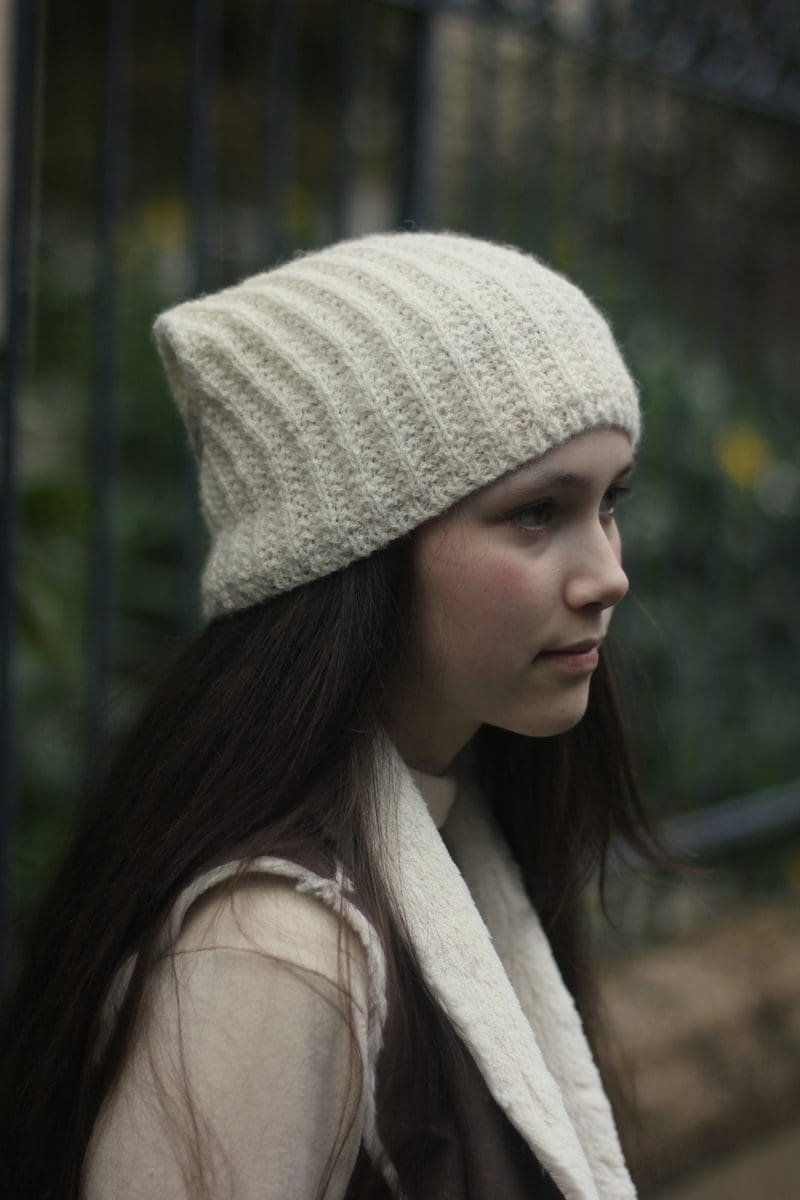 Young woman wearing a knit beanie hat. Winter fashion, warm headwear.