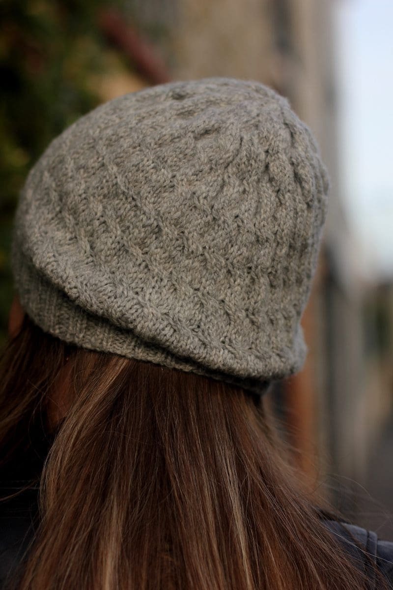 Woman wearing a soft swell beanie. Grey knitted hat. Winter fashion.